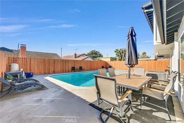 view of swimming pool with cooling unit and a patio