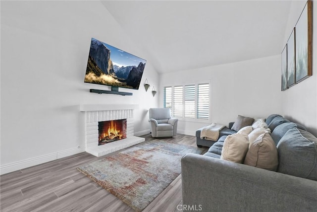 living room featuring a fireplace, hardwood / wood-style floors, and vaulted ceiling