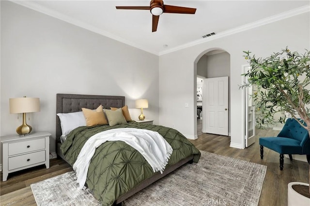 bedroom with ceiling fan, ensuite bath, dark hardwood / wood-style floors, and ornamental molding