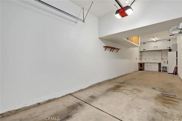 garage with white fridge and a garage door opener