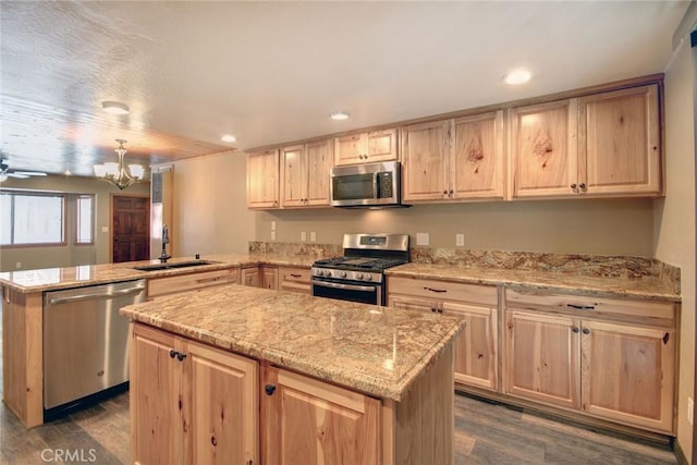 kitchen featuring stainless steel appliances, a kitchen island, sink, and kitchen peninsula