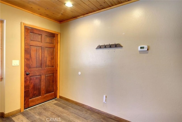 foyer entrance with hardwood / wood-style flooring, ornamental molding, and wooden ceiling