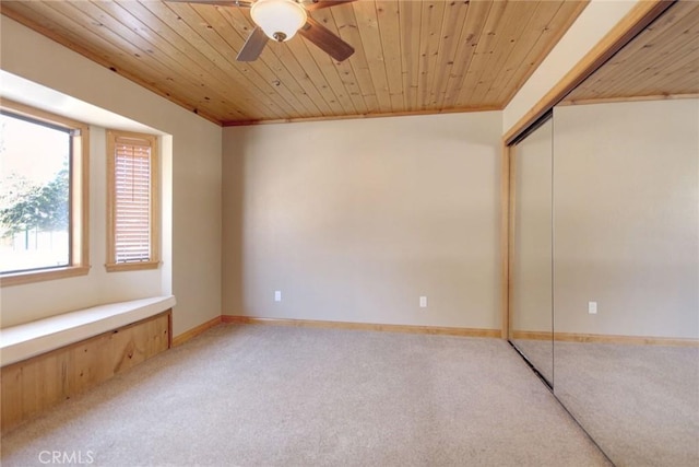 unfurnished bedroom featuring wooden ceiling, carpet flooring, ceiling fan, a closet, and crown molding