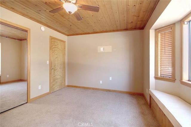 interior space with ornamental molding, light colored carpet, wooden ceiling, and ceiling fan