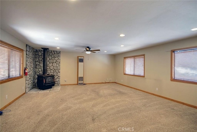 unfurnished living room featuring ceiling fan, a healthy amount of sunlight, and light colored carpet