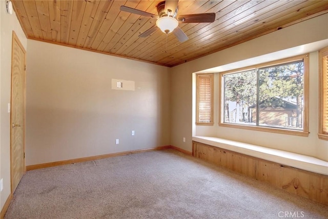 carpeted spare room with ceiling fan, crown molding, and wood ceiling