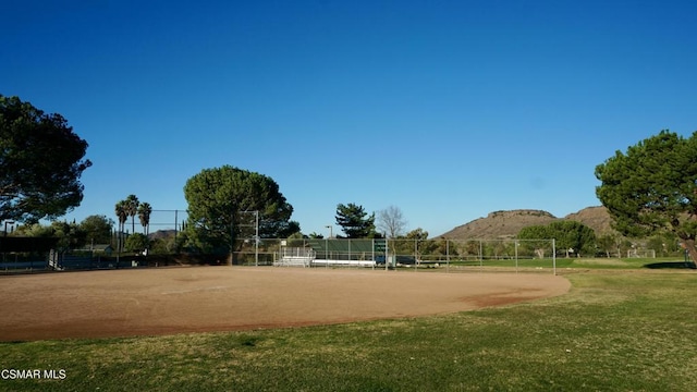 view of property's community with a rural view, a mountain view, and a lawn