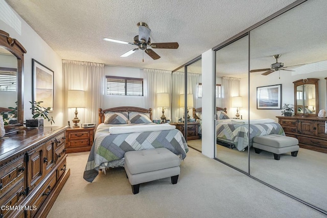 carpeted bedroom with multiple windows, multiple closets, and ceiling fan