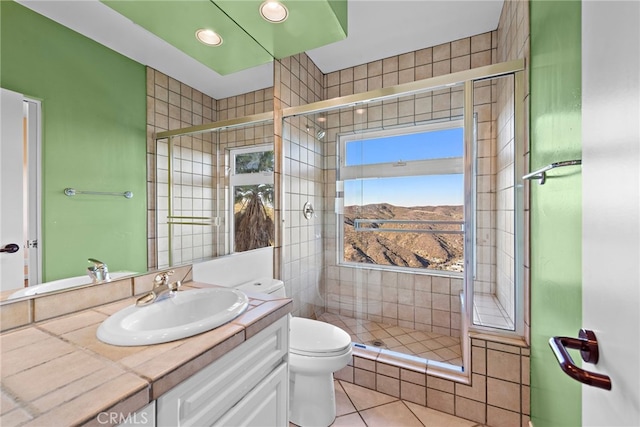 bathroom with a shower with door, tile patterned flooring, vanity, and toilet