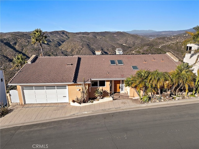 view of front facade with a garage and a mountain view