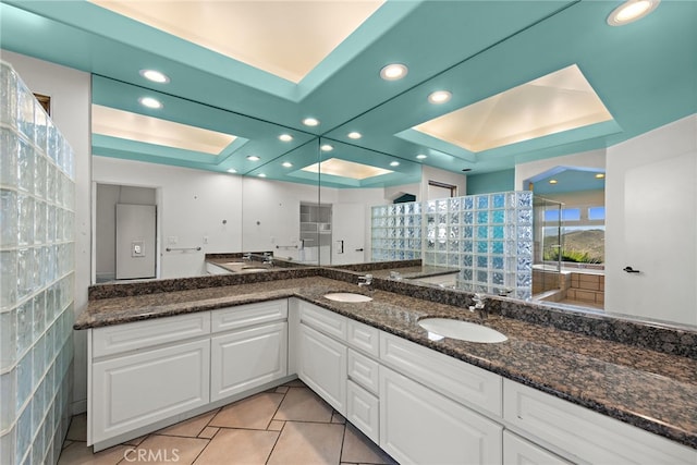 bathroom with vanity, a raised ceiling, and tile patterned floors