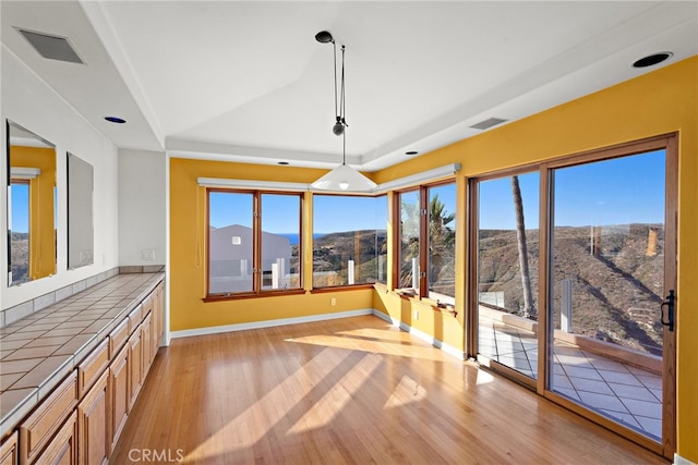 unfurnished dining area with light wood-type flooring and a mountain view