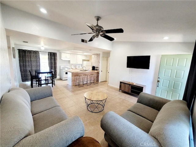 living room with ceiling fan, sink, and light tile patterned flooring