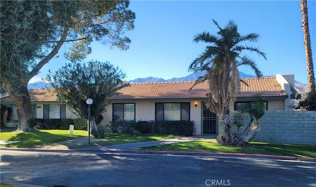 ranch-style house featuring a mountain view and a front yard