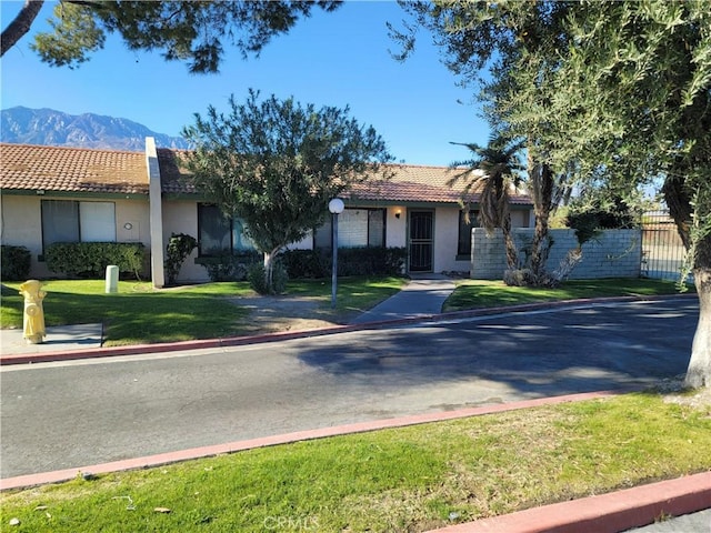 view of front facade featuring a mountain view and a front lawn