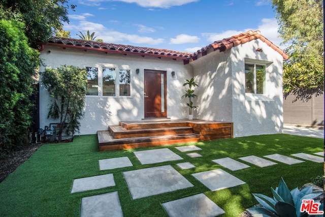 mediterranean / spanish home featuring a front yard