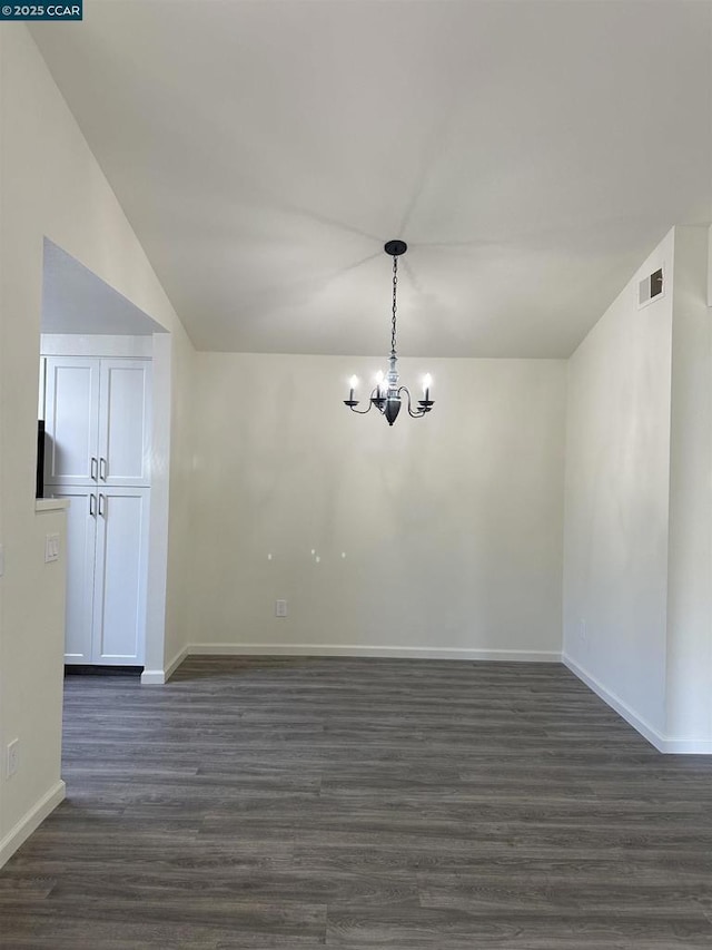 unfurnished dining area featuring lofted ceiling, dark wood-type flooring, and a chandelier