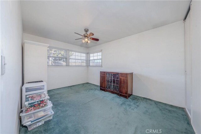 unfurnished room with ceiling fan and carpet