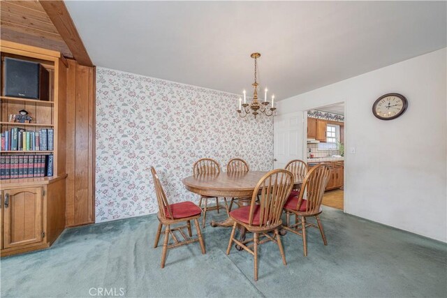 carpeted dining area featuring a notable chandelier