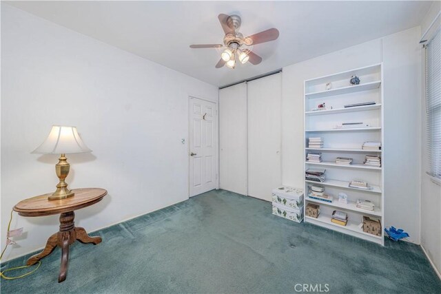 unfurnished room featuring ceiling fan, built in features, and dark carpet