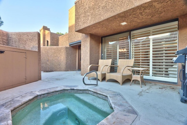 view of pool with a patio and an in ground hot tub