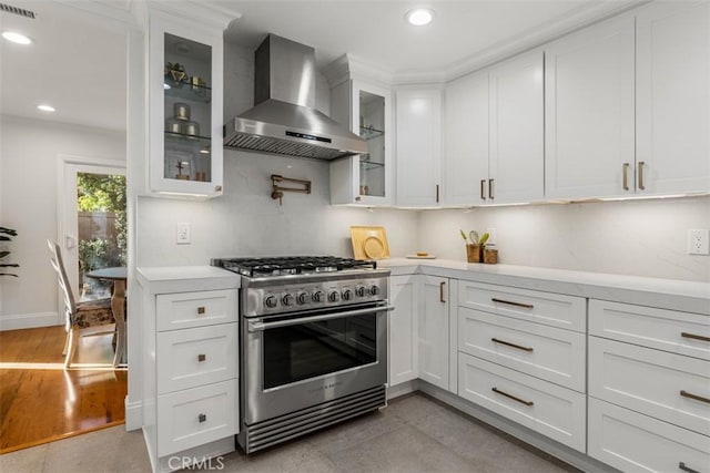 kitchen featuring stainless steel range, white cabinets, and extractor fan