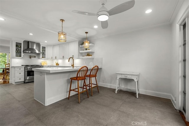 kitchen featuring recessed lighting, a peninsula, baseboards, high end stainless steel range oven, and wall chimney exhaust hood