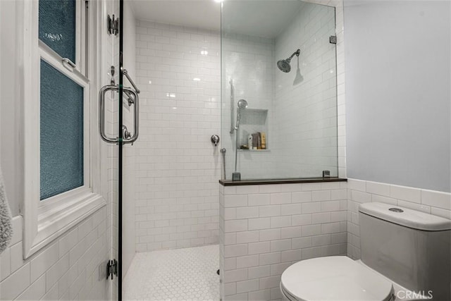 full bathroom with a shower stall, toilet, and tile walls