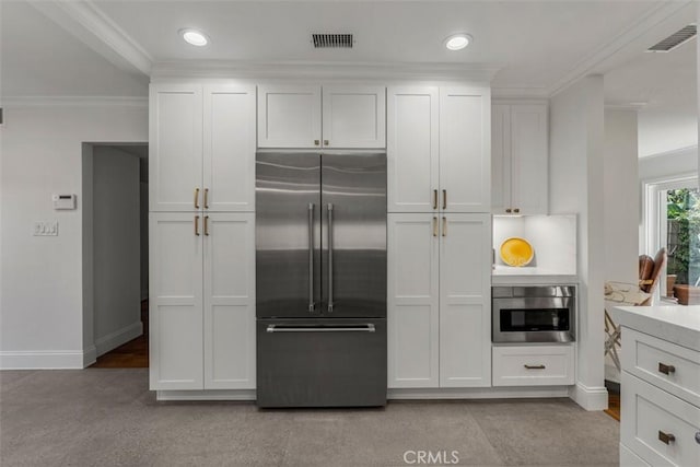 kitchen with visible vents, baseboards, white cabinets, ornamental molding, and appliances with stainless steel finishes