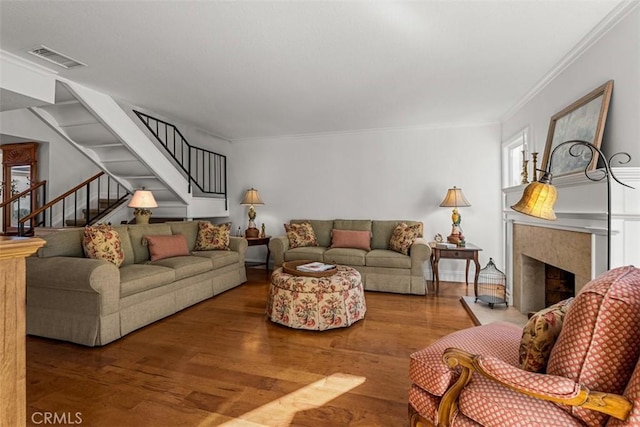 living room featuring ornamental molding, a high end fireplace, and wood-type flooring