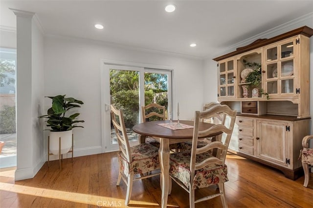 dining room featuring hardwood / wood-style flooring, ornamental molding, and recessed lighting