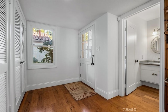 foyer with light wood-type flooring and baseboards