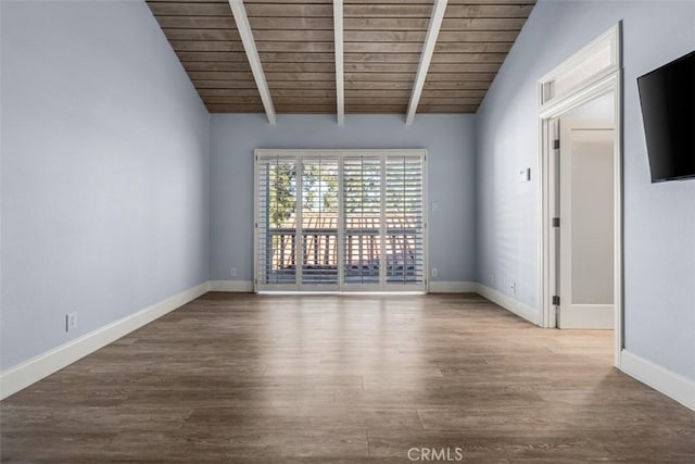 spare room with lofted ceiling with beams, baseboards, and wood finished floors