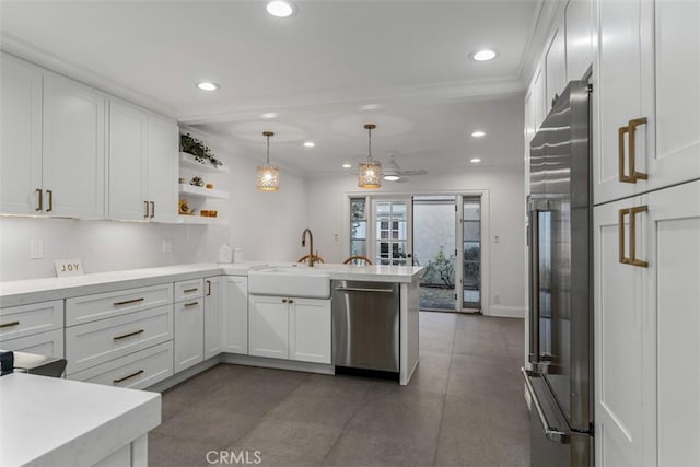 kitchen with stainless steel appliances, a peninsula, a sink, white cabinets, and light countertops