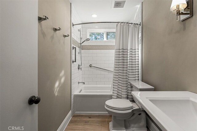 full bathroom with shower / bathtub combination with curtain, toilet, sink, and hardwood / wood-style flooring