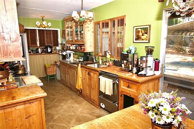 kitchen with dishwasher, sink, a chandelier, and pendant lighting