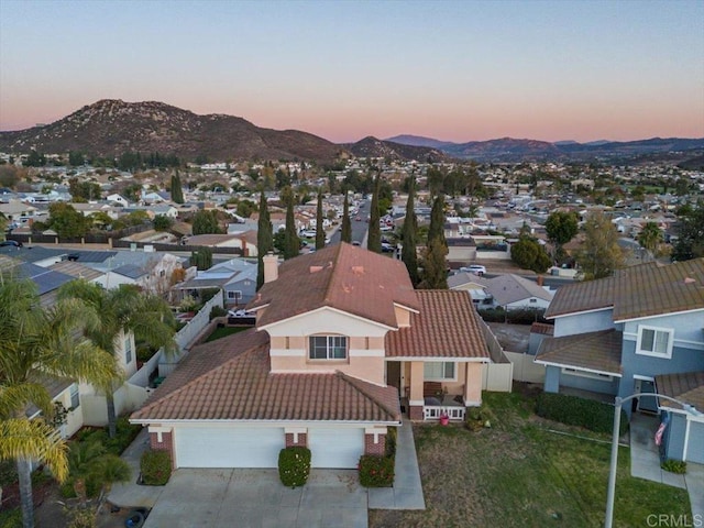 aerial view at dusk featuring a mountain view