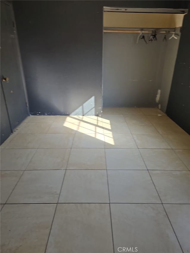 unfurnished bedroom with light tile patterned floors and a closet