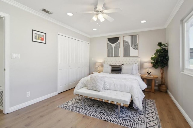 bedroom with a closet, ceiling fan, light wood-type flooring, and crown molding