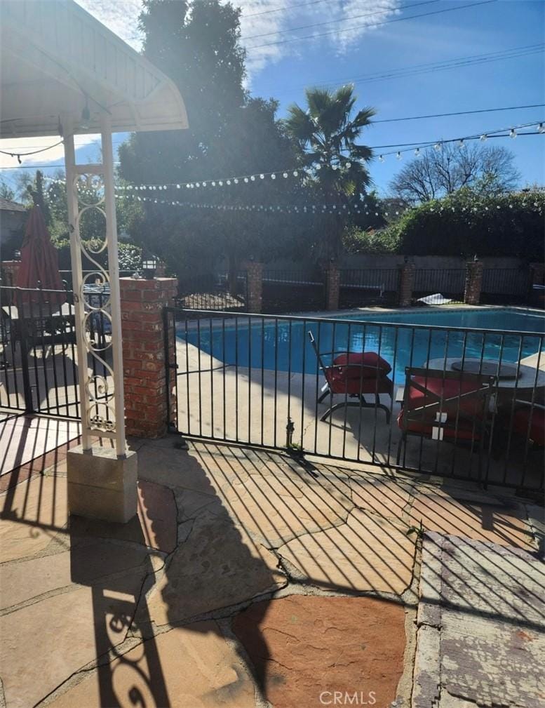 view of swimming pool featuring a gate, fence, and a pool