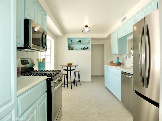 kitchen featuring stainless steel appliances, blue cabinets, and sink