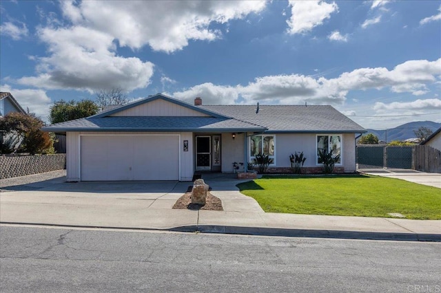 single story home featuring a garage, a mountain view, and a front lawn