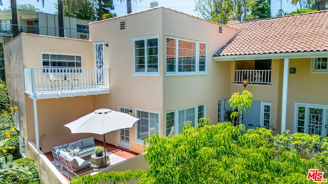 back of house with a balcony and an outdoor hangout area