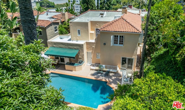 rear view of property with an outdoor living space and a patio