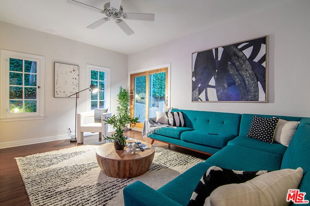 living room featuring ceiling fan and dark hardwood / wood-style floors