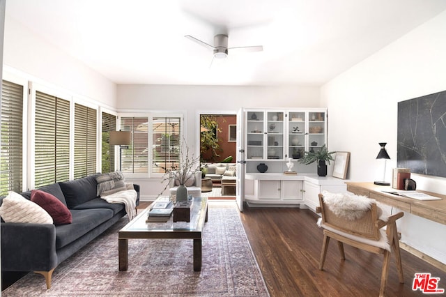 living room with dark wood-type flooring and ceiling fan