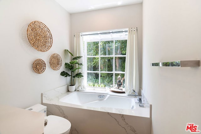 bathroom featuring toilet and a tub