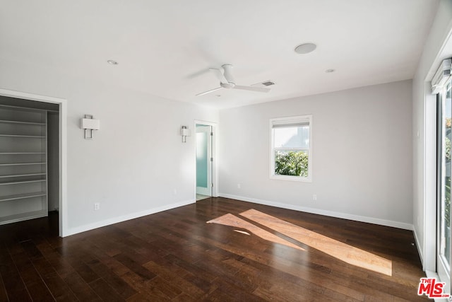 unfurnished room with ceiling fan and dark hardwood / wood-style flooring