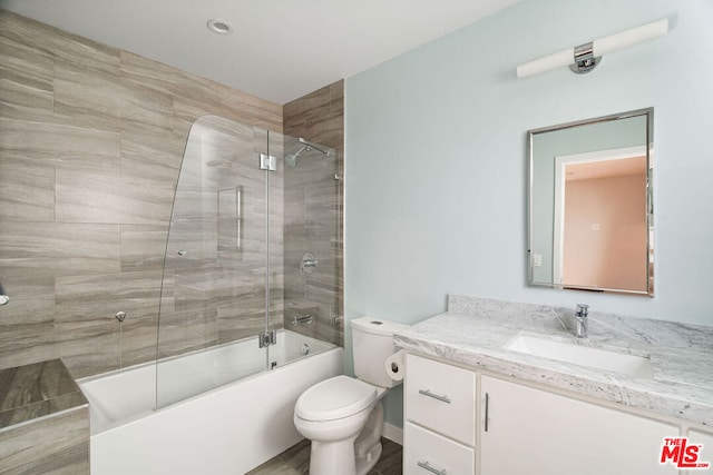 full bathroom featuring toilet, tiled shower / bath combo, and vanity