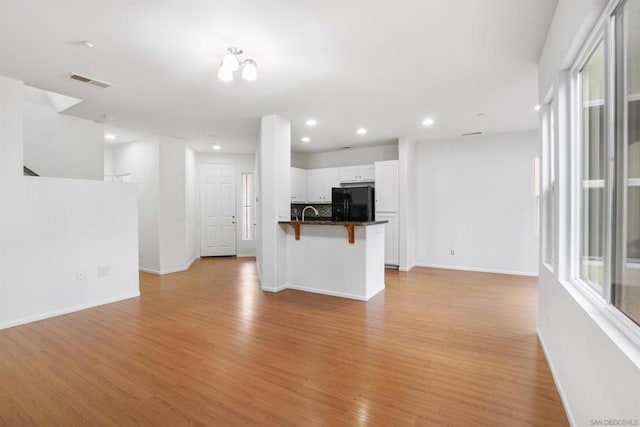 unfurnished living room featuring a healthy amount of sunlight and light hardwood / wood-style flooring